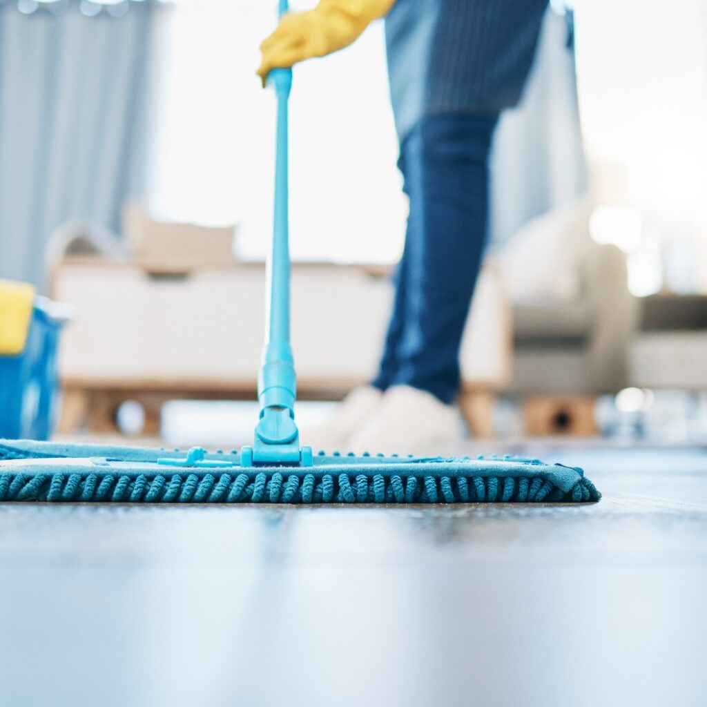 Hauswirtschaft, Reinigung und Hausmädchen mit einem Mopp, um den Boden im Wohnzimmer eines Hauses zu reinigen. Weibliche Hausangestellte, Putzfrau und Hausfrau, die den Boden in ihrem Haus von Bakterien, Staub und Schmutz befreit.