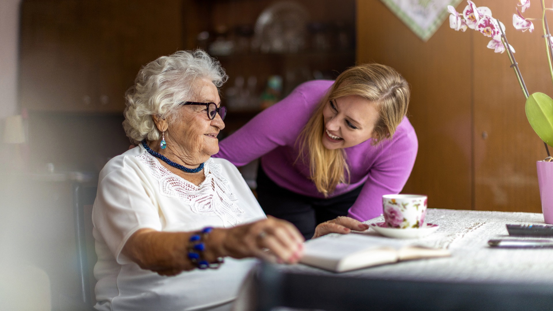 Young woman spending time with her elderly grandmother at home